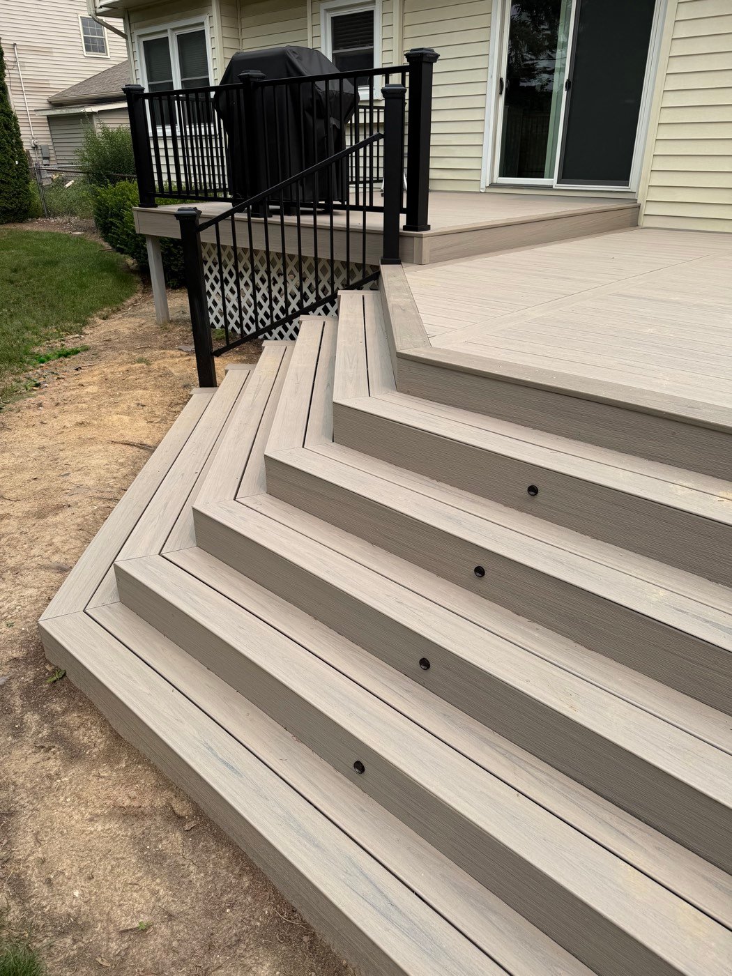 Wraparound composite deck stairs with built-in riser lights