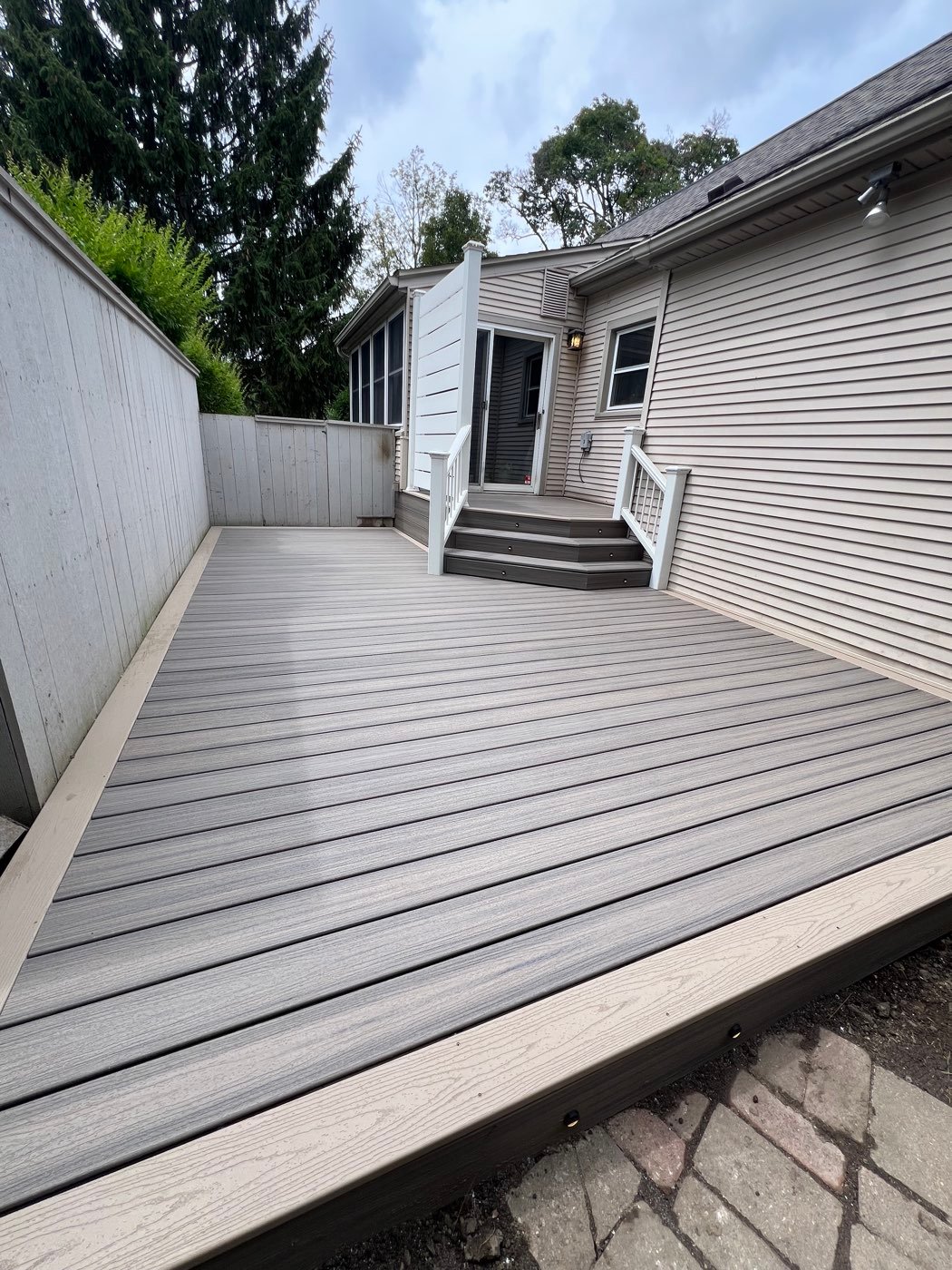 Gray composite deck off the back of a home