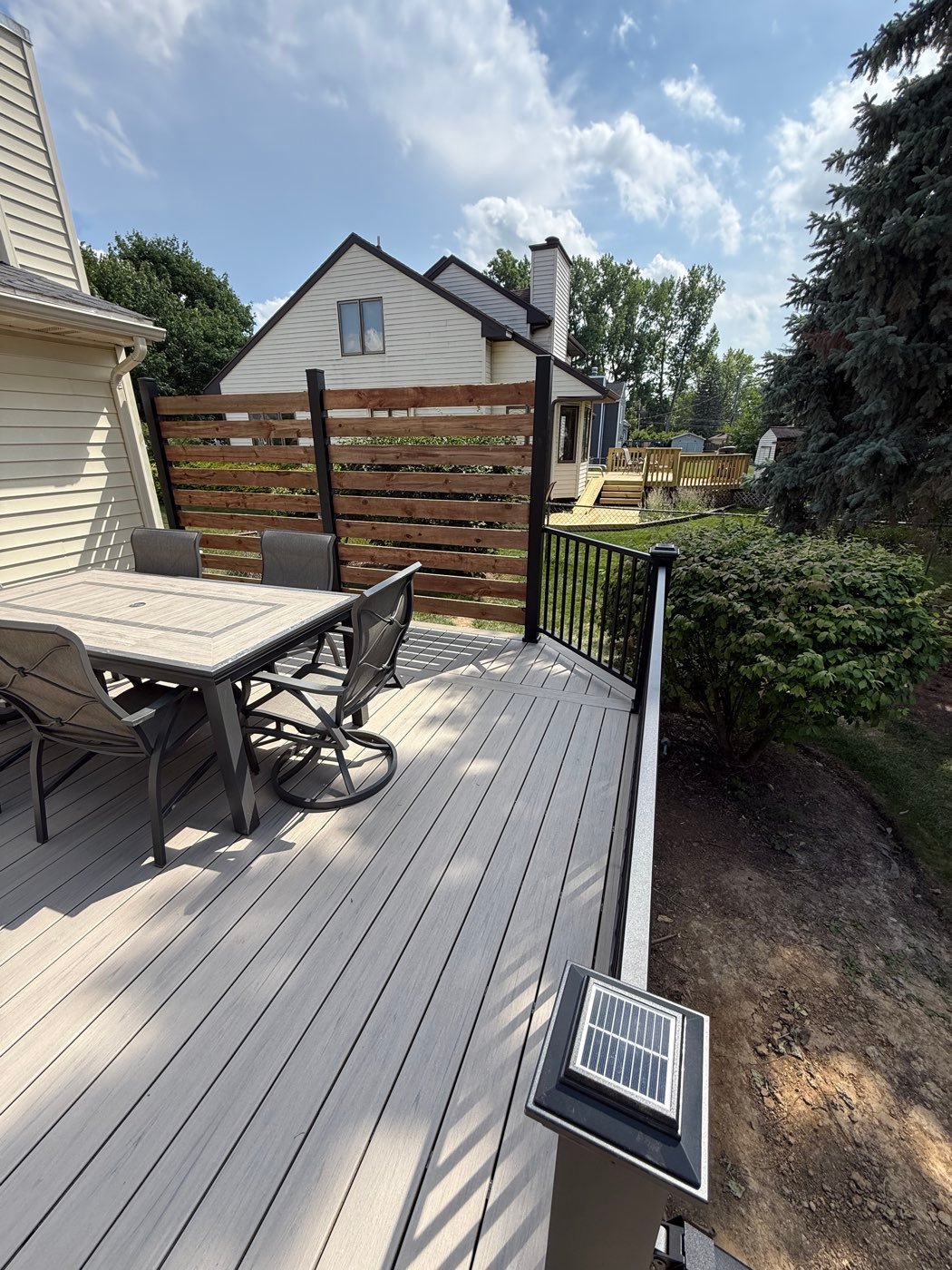 Composite deck with a privacy wall and patio set