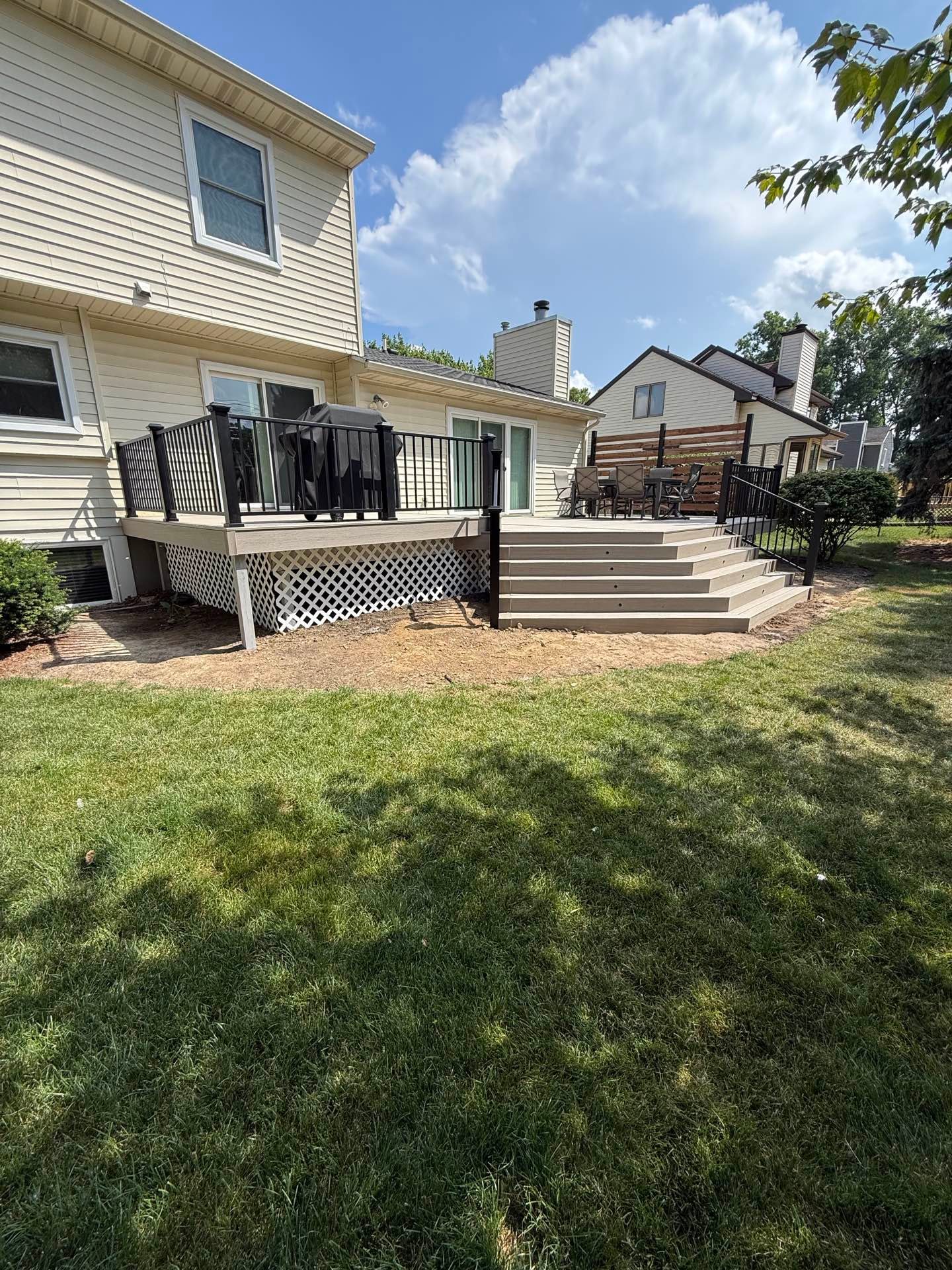 Composite deck with black railing and wide stairs