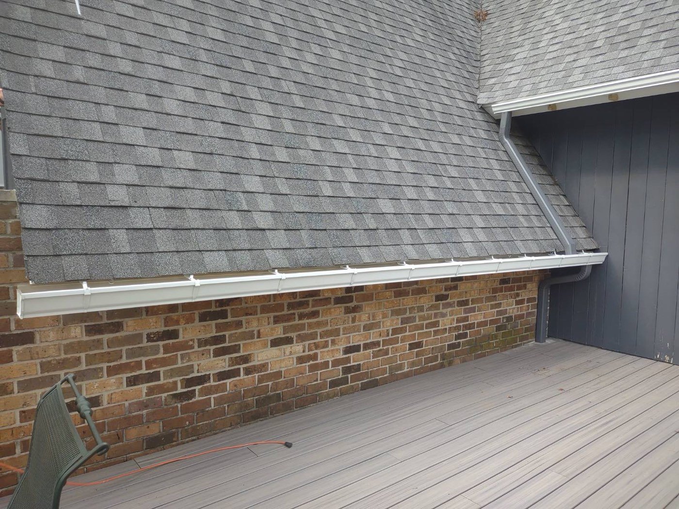 New white seamless gutter and downspout on a brick home