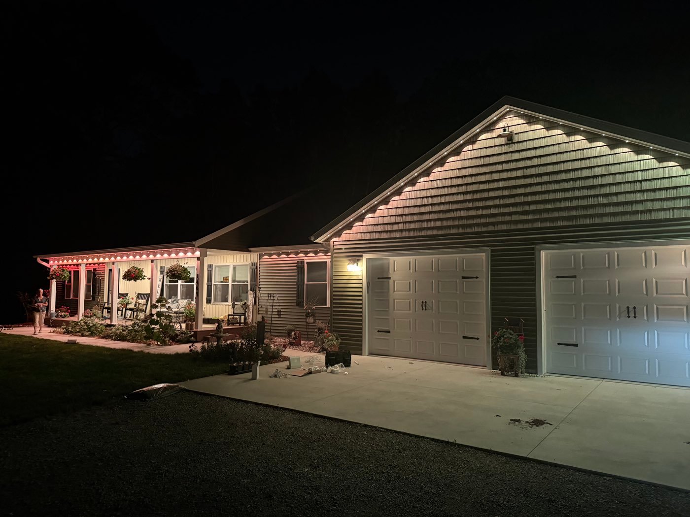 Home at night with white soffit lighting along the roofline and porch