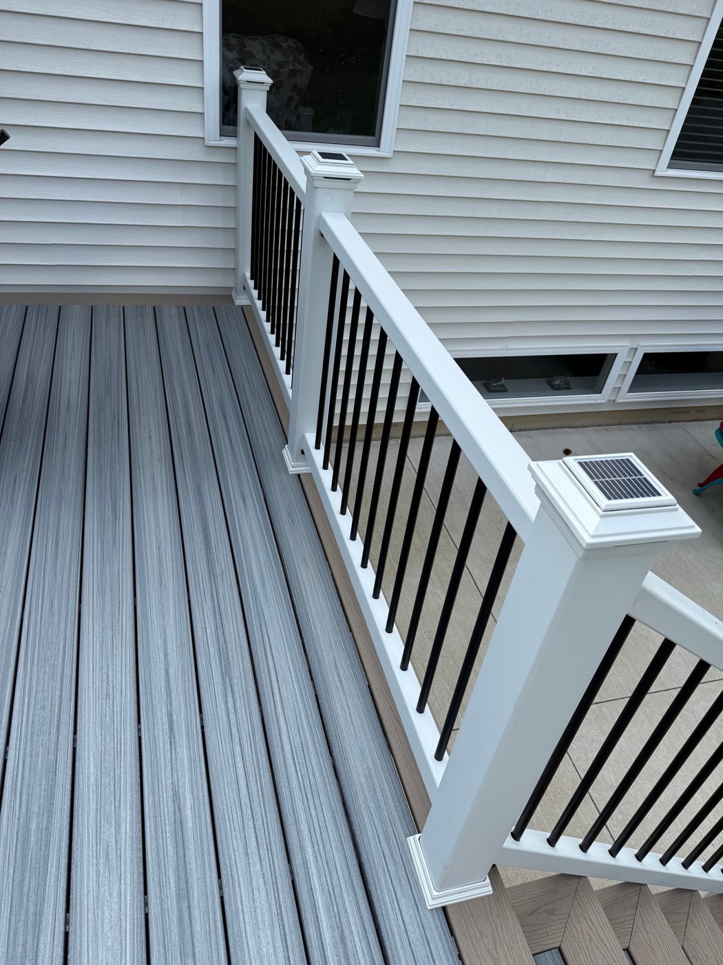 Lighted post caps on a white deck railing